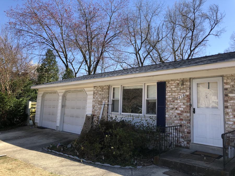 Front of a brick rancher with new white seamless gutters