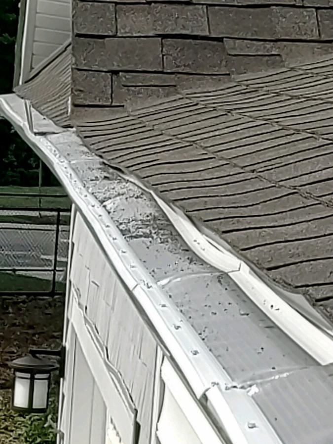 A gutter guard that has buckled and warped along the run